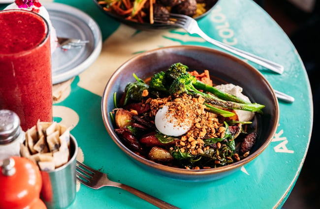Close up of Houghton Bay Bowl at Worker placing bowl of food on table at Maranui Cafe in Lyall Bay Wellington