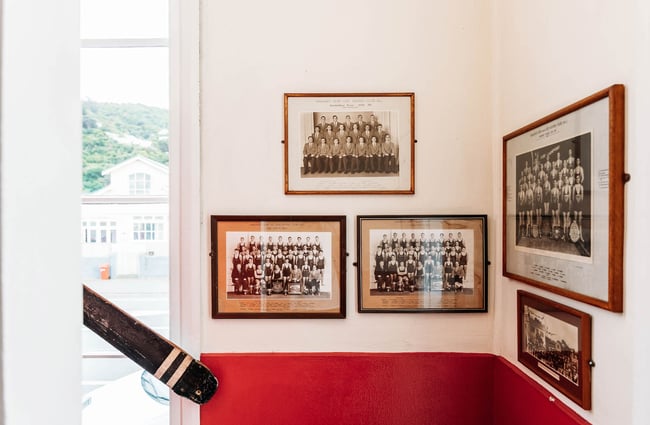 Historical photographs framed on wall at Worker placing bowl of food on table at Maranui Cafe in Lyall Bay Wellington