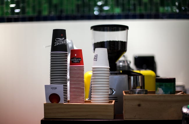 Coloured takeaway coffee cups on top of the coffee machine at Marbecks.
