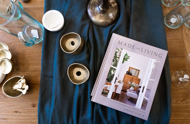 A flatly of a book and little pots on a table.