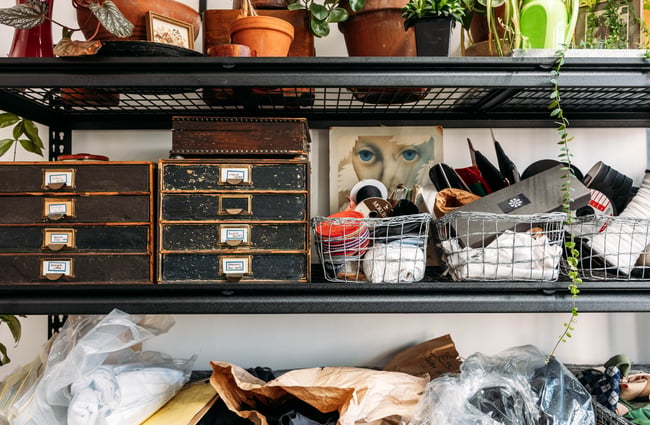 A close up of shelves full of knick knacks lined up against a white wall.