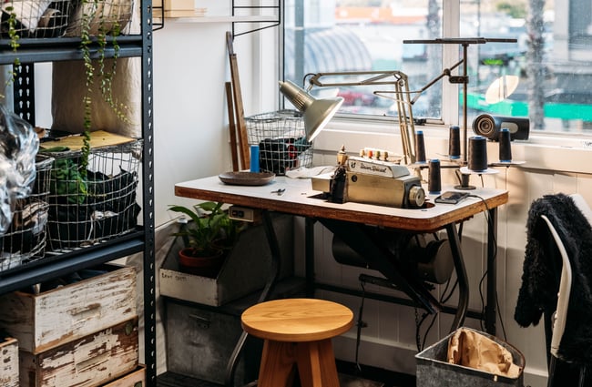 A sewing machine on a table inside a retail store's window.