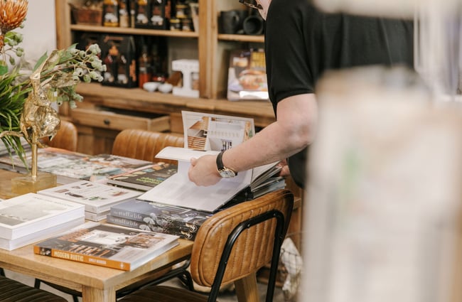 Man browsing a book at Matilda and The Metalman, Fairlie.