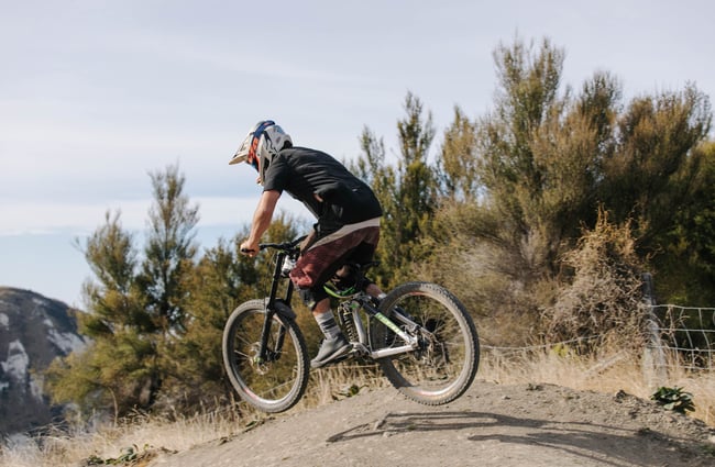 Man doing little jump on his mountain bike.