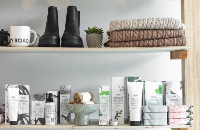 Close up of skin products, soaps, shoes and woollens displayed on shelves.