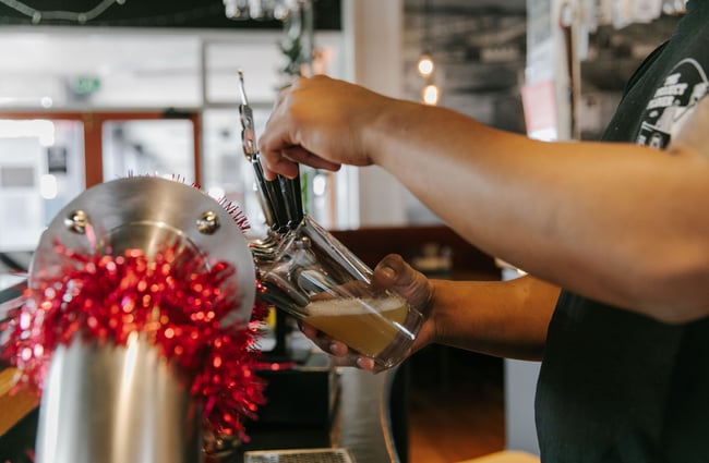 Close up of a man pouring a pint at Ministry of Works, Twizel.