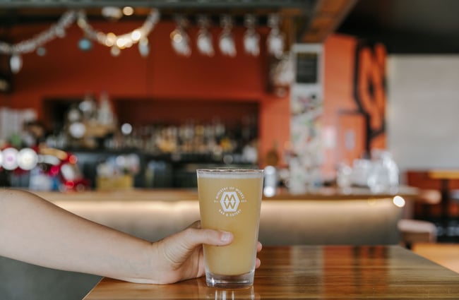 Hand holding a glass of beer from Ministry of Works, Twizel.