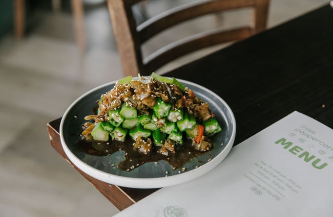 A black and grey plate stacked with layers of food.