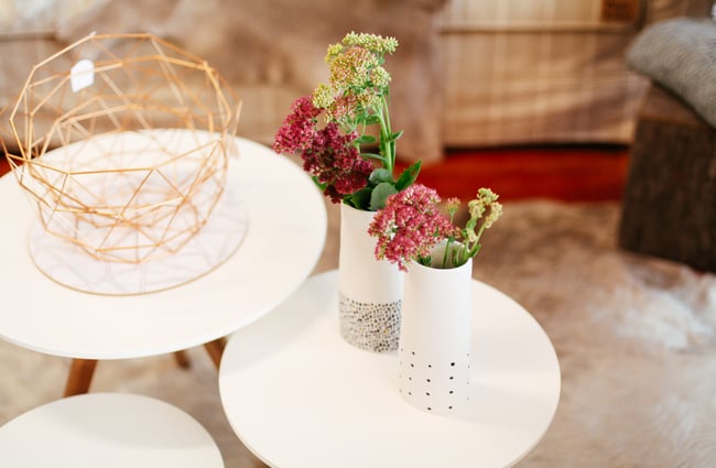Vases of flowers on a small white table.