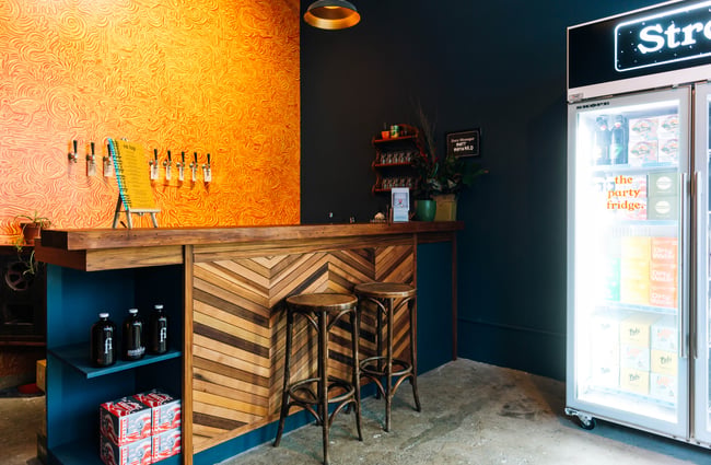 View of a couple of wooden stools at cosy wooden bar at Monkfish, Wellington.