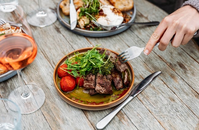 Customer cutting into food at Monte Christo Winery.