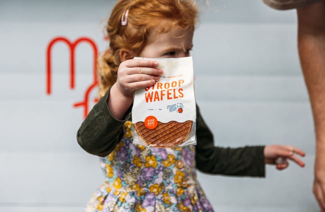 A child holding a bag of bagels.