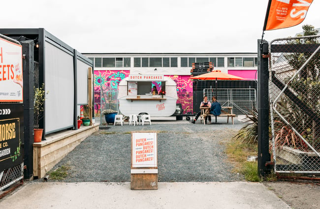 A food caravan in a yard.