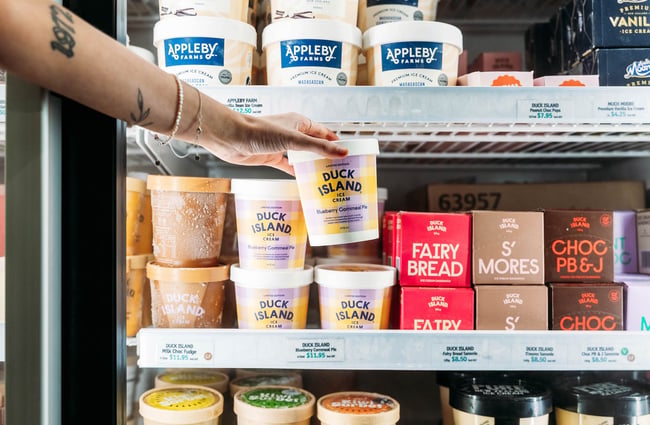 Person reaching into freezer for Duck Island ice cream at Moore Wilson's in Wellington