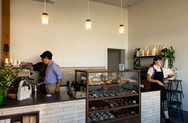 Two staff members working inside a cafe.