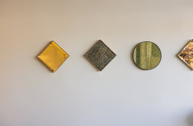 Small works of art on a wall inside a cafe.