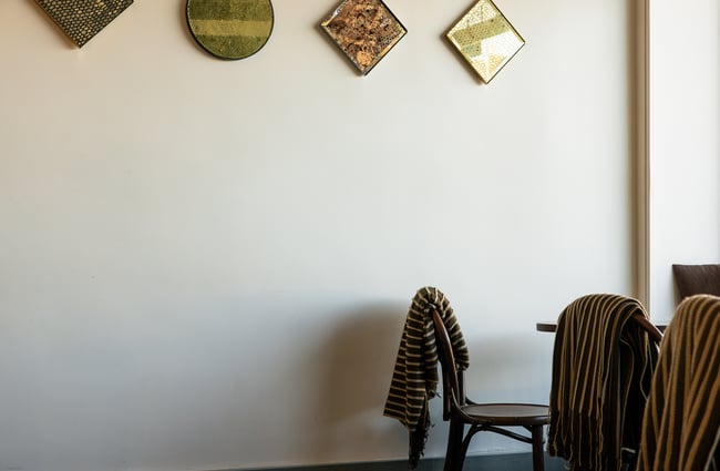 Tables and chairs next to a window at Mor Bakery.