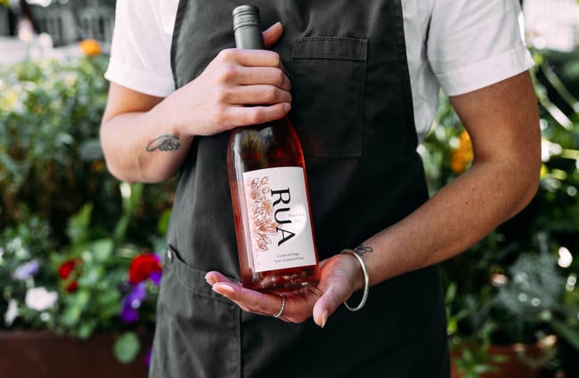 A person holding a bottle of wine.