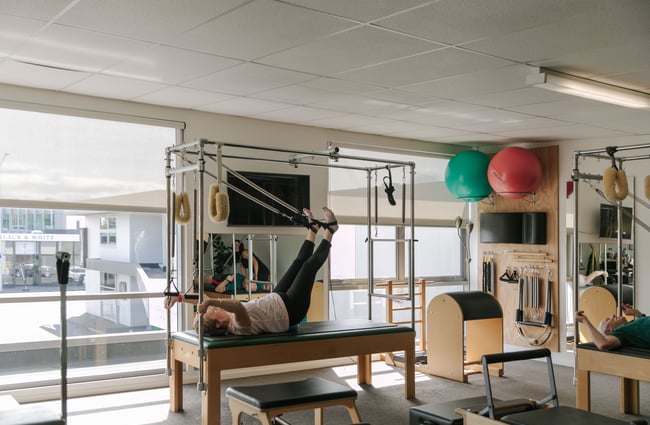 A woman on a reformer Pilates machine.
