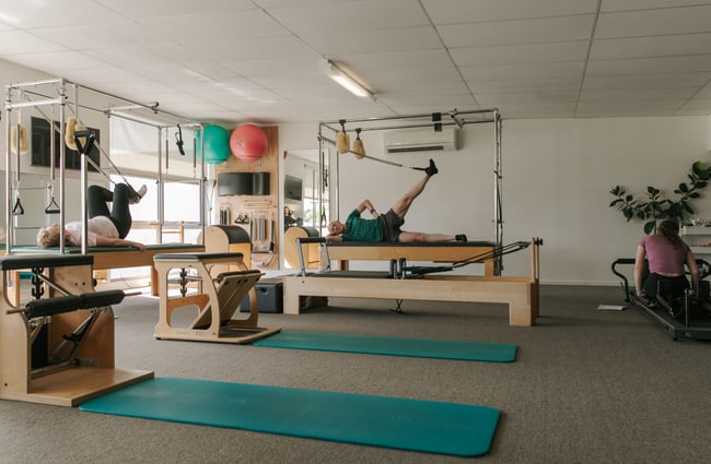 A man on a reformer pilates studio.