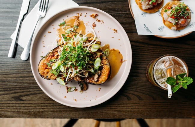 Birds eye view of savoury dishes and a cocktail on a table.