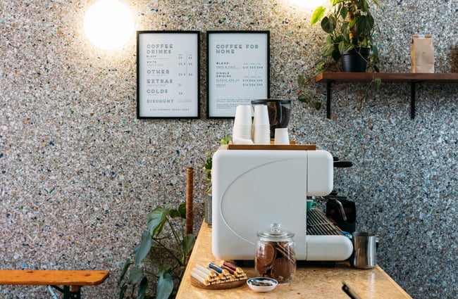 A coffee machine next to a concrete look wall inside Mr Clifton's Gisborne.