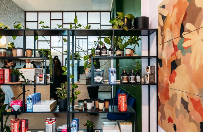 Coffee equipment on black shelving inside a cafe.