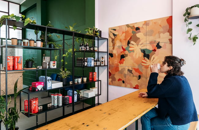 A woman drinking coffee at a cafe table.