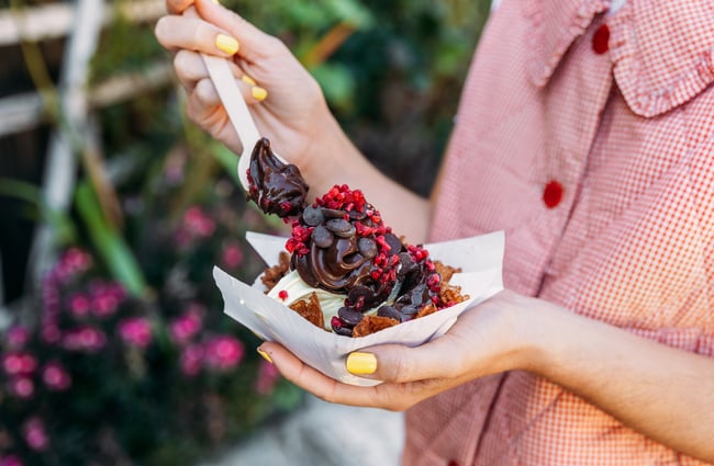A close up hands holding a chocolate dessert.