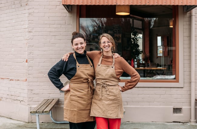 Two women smiling to camera.