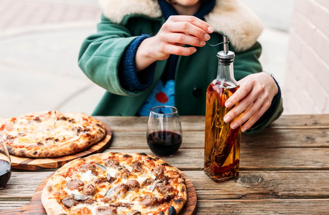 A person opening a bottle of chilli oil.