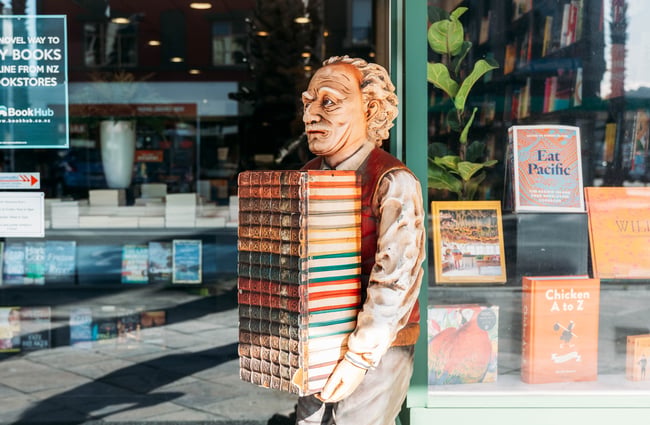 A close up of a statue of a man holding books.