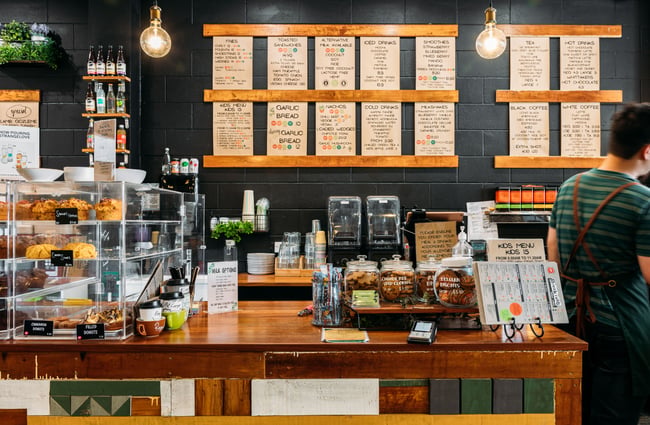 A man standing at the counter at a cafe.