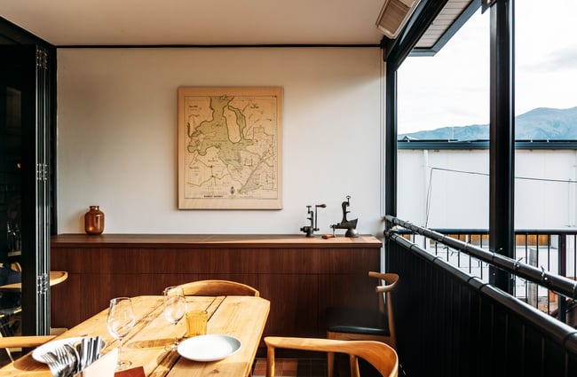 A table is on the enclosed balcony dining area at Muttonbird, Wānaka.