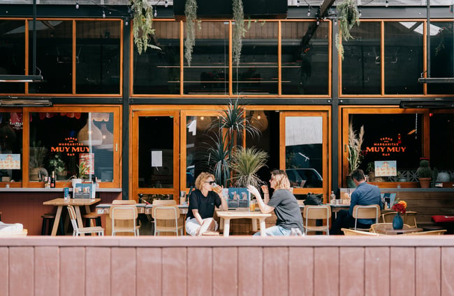 Friends drinking together outside at Muy Muy in Christchurch