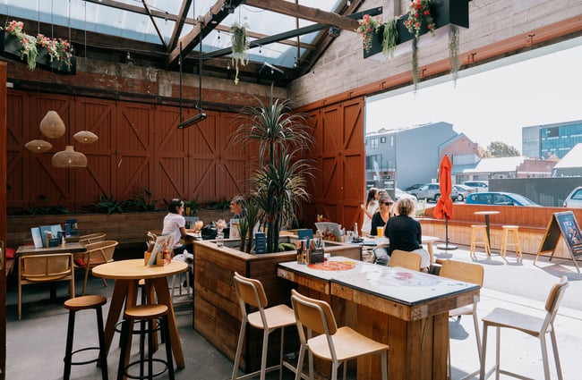 People eating and drinking in outdoor courtyard area at Muy Muy in Christchurch