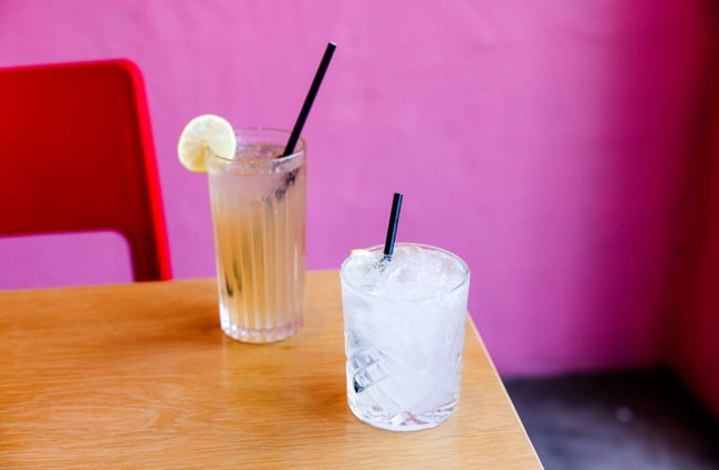 Two cocktails sit on the edge of the table at Neighbourhood Cantina.
