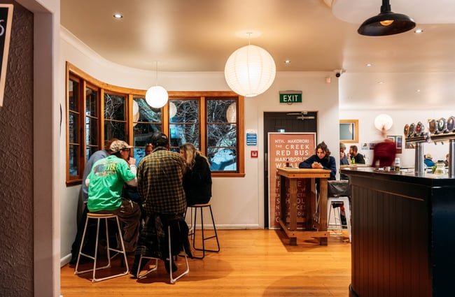 Customers sitting at a high table in Neighbourhood Pizzeria Gisborne.