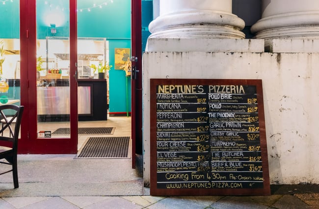 A chalkboard menu resting outside Neptunes Pizzeria Gisborne.