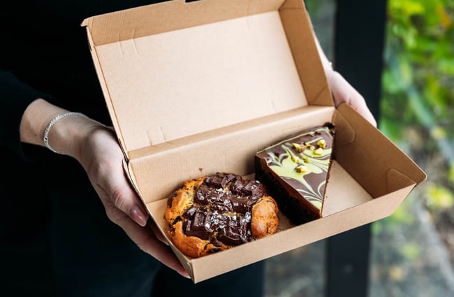 A cookie and slice in a box from Neverland Cakes.
