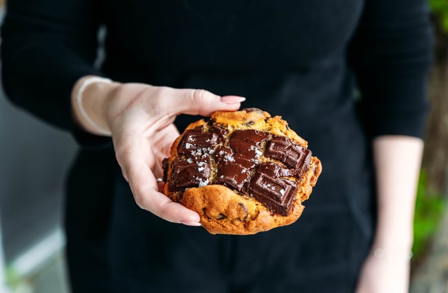 Customer holding a cookie at Neverland Cakes.