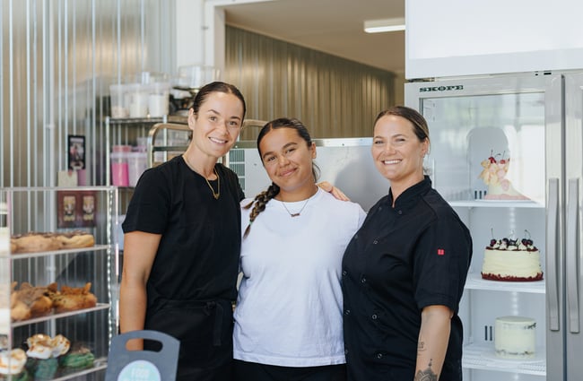 Three staff members standing in the kitchen at Neverland Cakes.