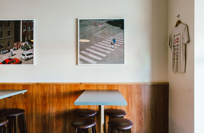 Leaner tables and artwork on the wall at Next Door, Wellington.