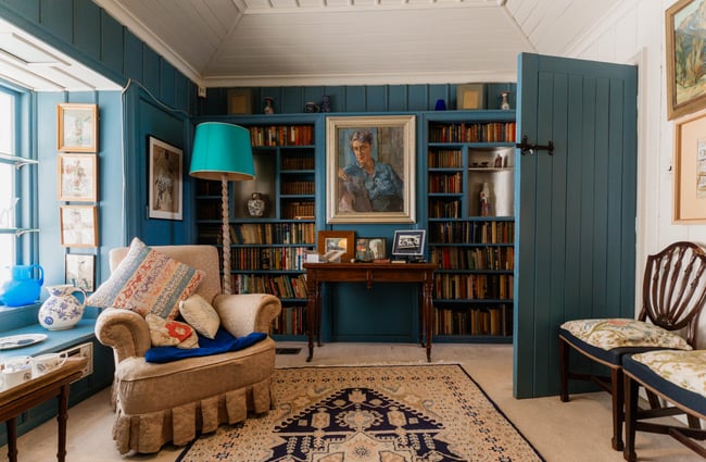 A shelf full of old books in an old style living room.