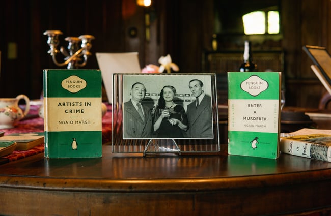 Two green books on either side of a black and white portrait of people.