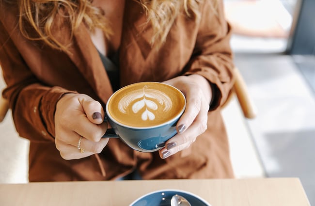 Close up of woman holding a coffee at Niche Cafe and Eatery in Sumner.