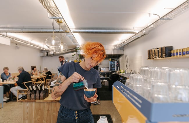 Woman pouring hot milk into cup at Niche Cafe and Eatery in Sumner.