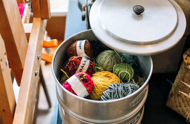 Balls of coloured wool in a tub.