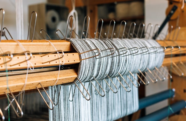 Close up of yarns on a loom.
