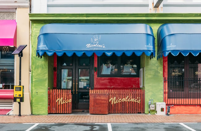 Green building exterior of Nicolini's and blue awning.
